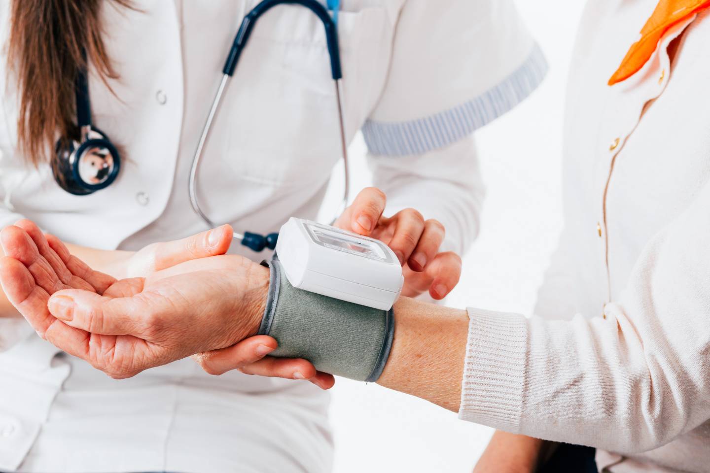 A healthcare professional skillfully uses a digital blood pressure monitor on a patient's wrist, seamlessly integrating dynamic content to enhance the assessment.